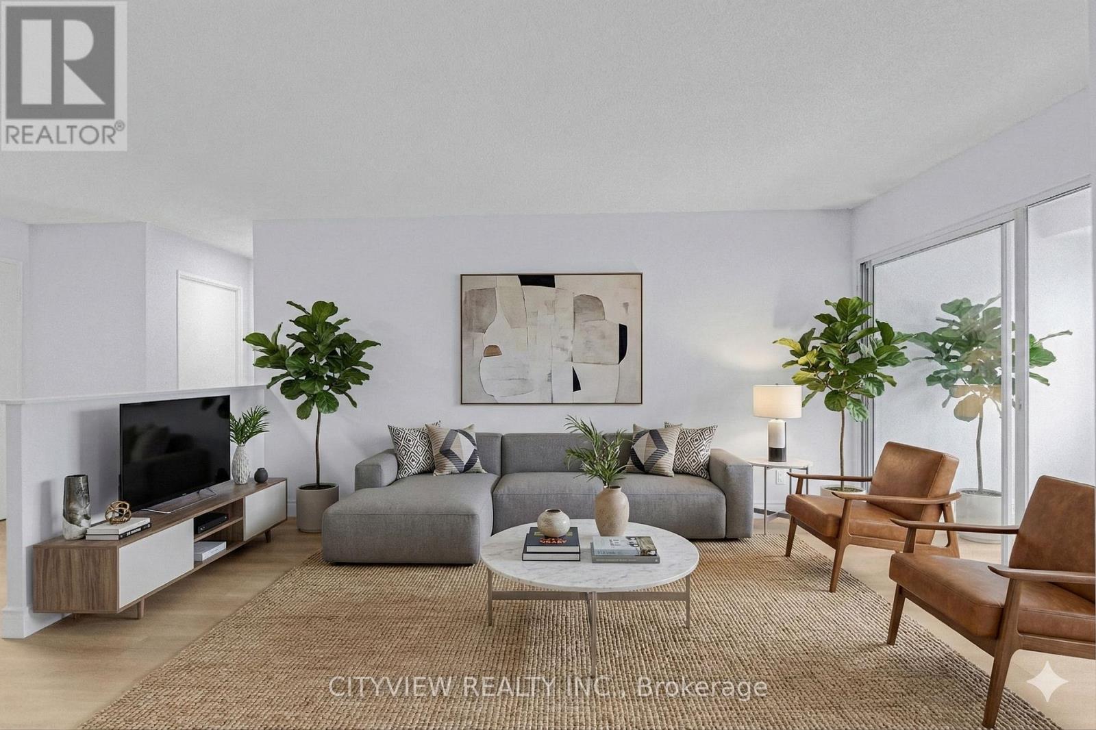 A living room with a grey couch, a coffee table, and a television.