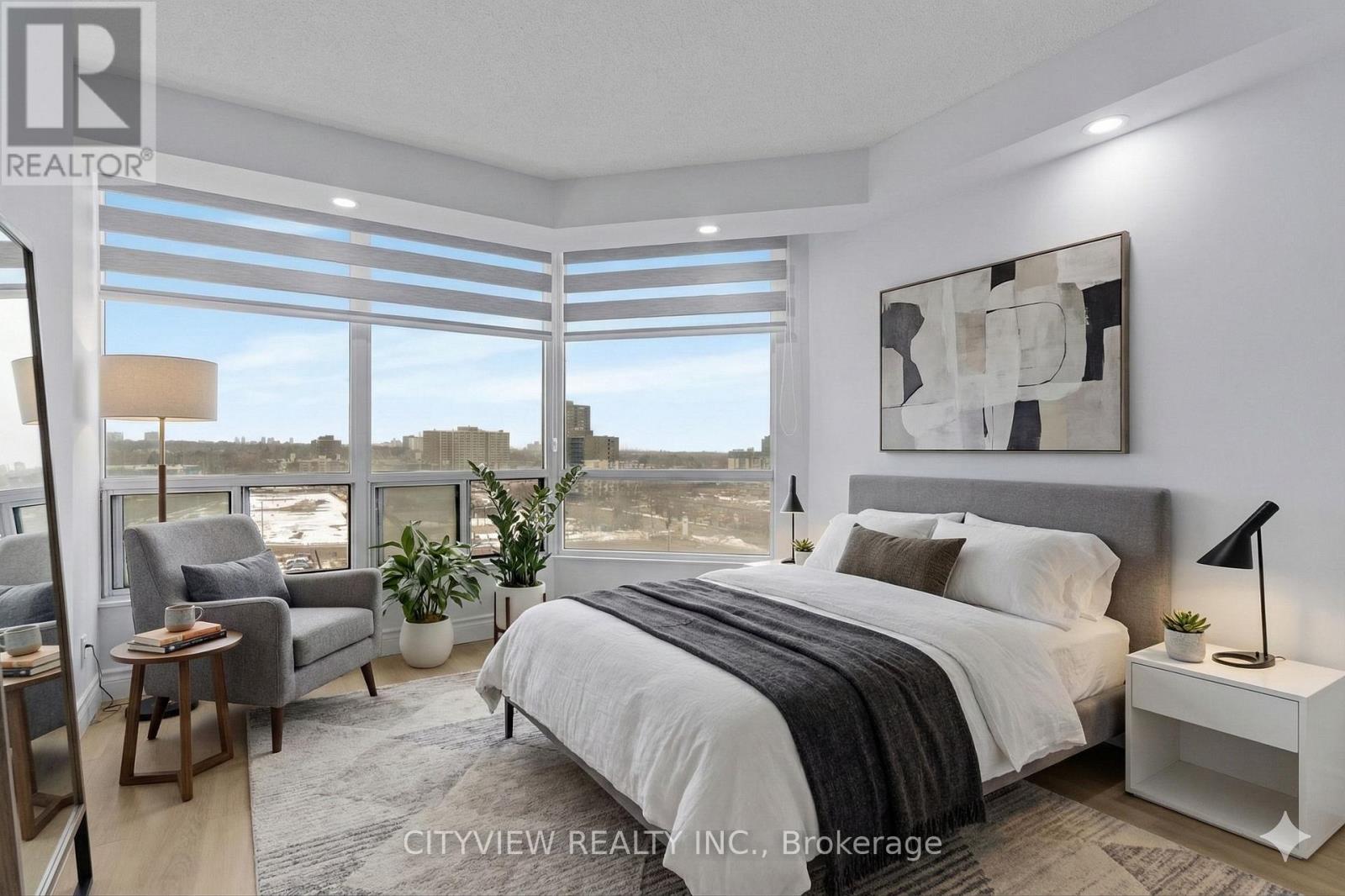 A bedroom with a large bed and a view of the city.