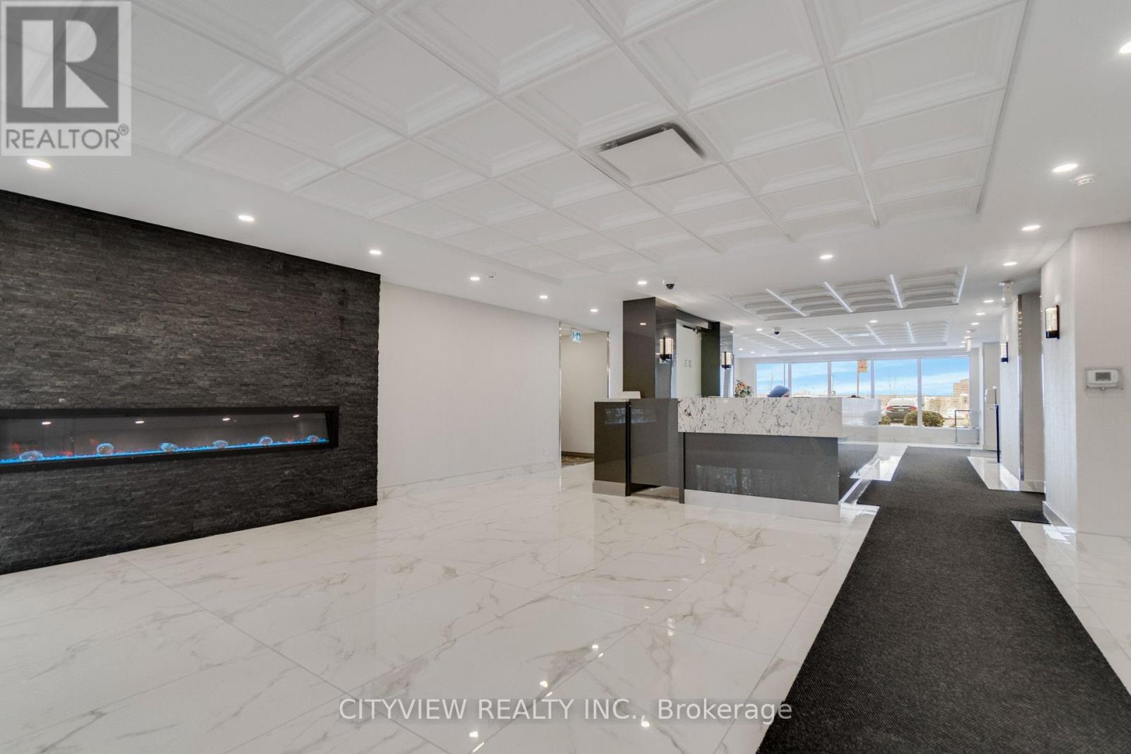 A spacious office lobby with a marble floor and a modern design.