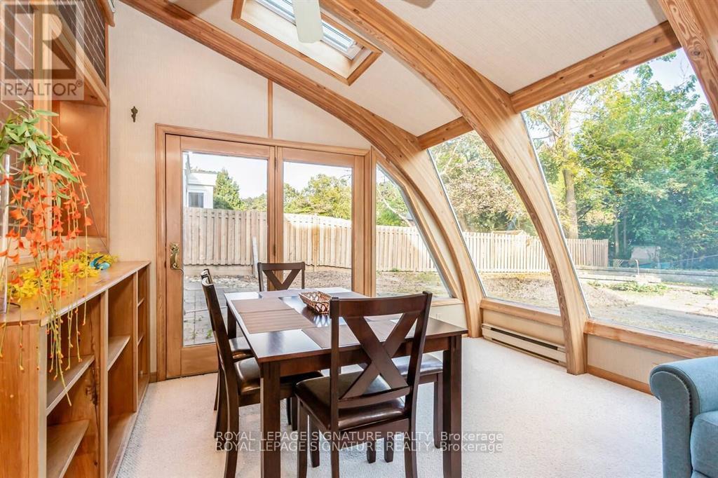 A dining room with a wooden table and chairs.