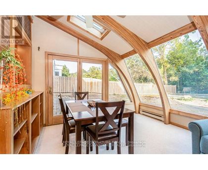 A dining room with a wooden table and chairs.
