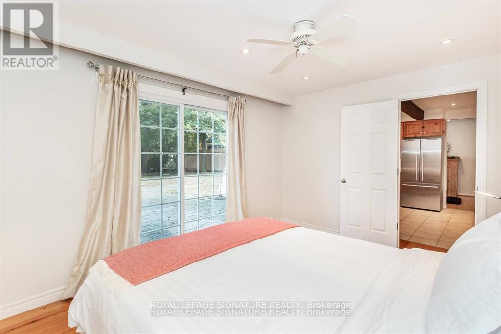 A bedroom with a large bed and a ceiling fan.
