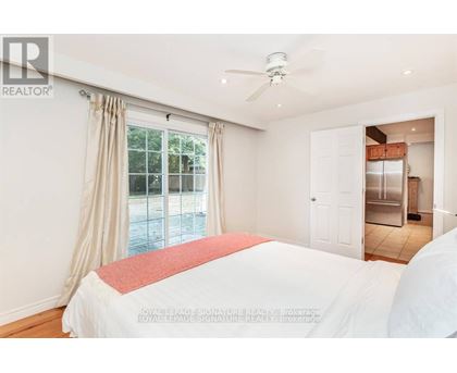 A bedroom with a large bed and a ceiling fan.