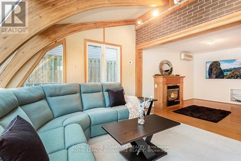 A living room with a blue couch and a fireplace.