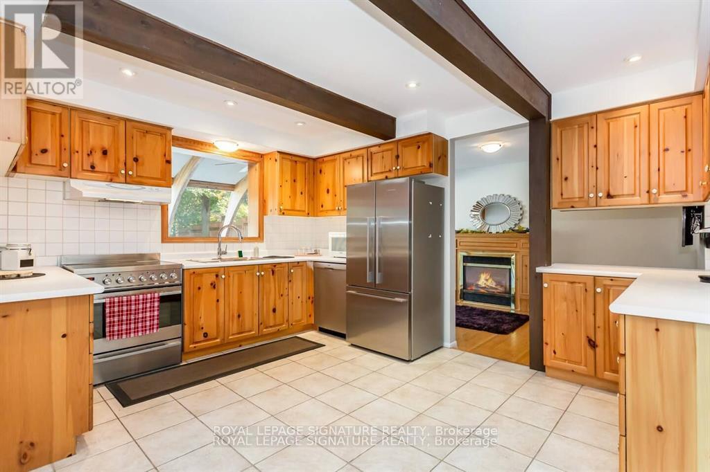 A kitchen with wooden cabinets and a stainless steel refrigerator.
