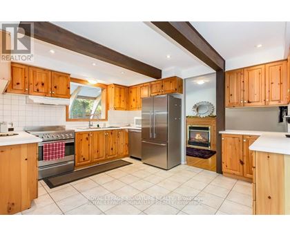A kitchen with wooden cabinets and a stainless steel refrigerator.