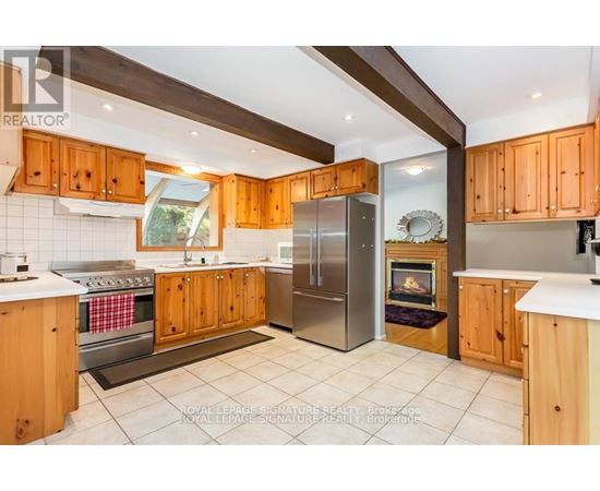 A kitchen with wooden cabinets and a stainless steel refrigerator.