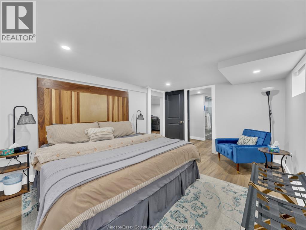 A bedroom with a large bed and a blue chair.