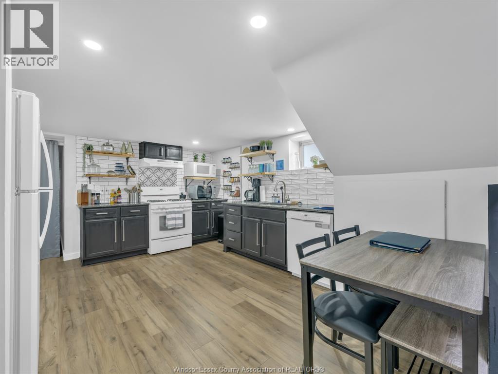 A kitchen with a table and chairs in front of it.