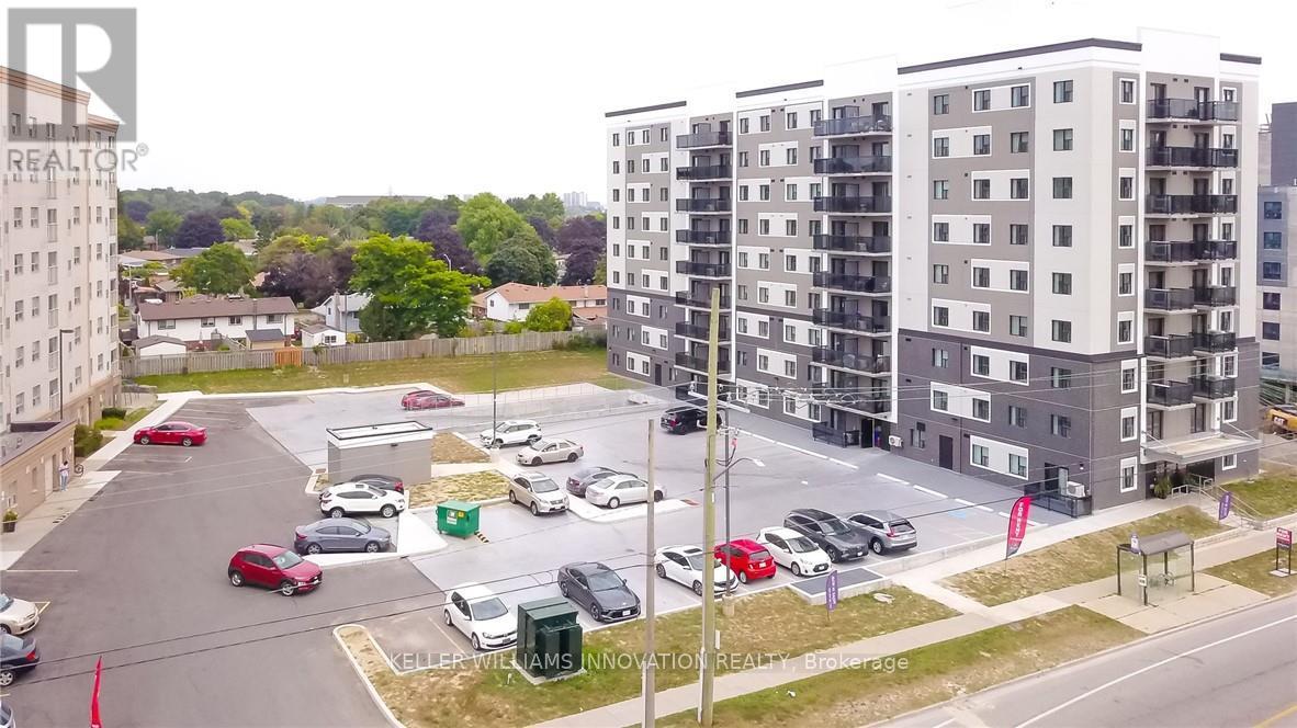 A parking lot with cars and apartment buildings in the background.