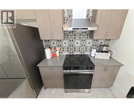 A kitchen with a stove top oven and a refrigerator.