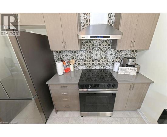 A kitchen with a stove top oven and a refrigerator.