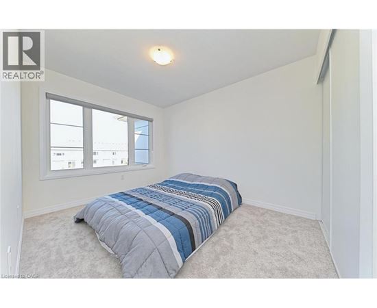 A bedroom with a bed and a window.