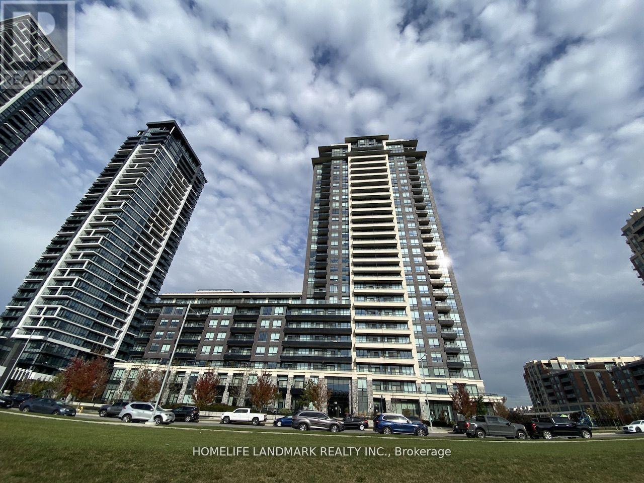 A modern building complex with cars parked in front.