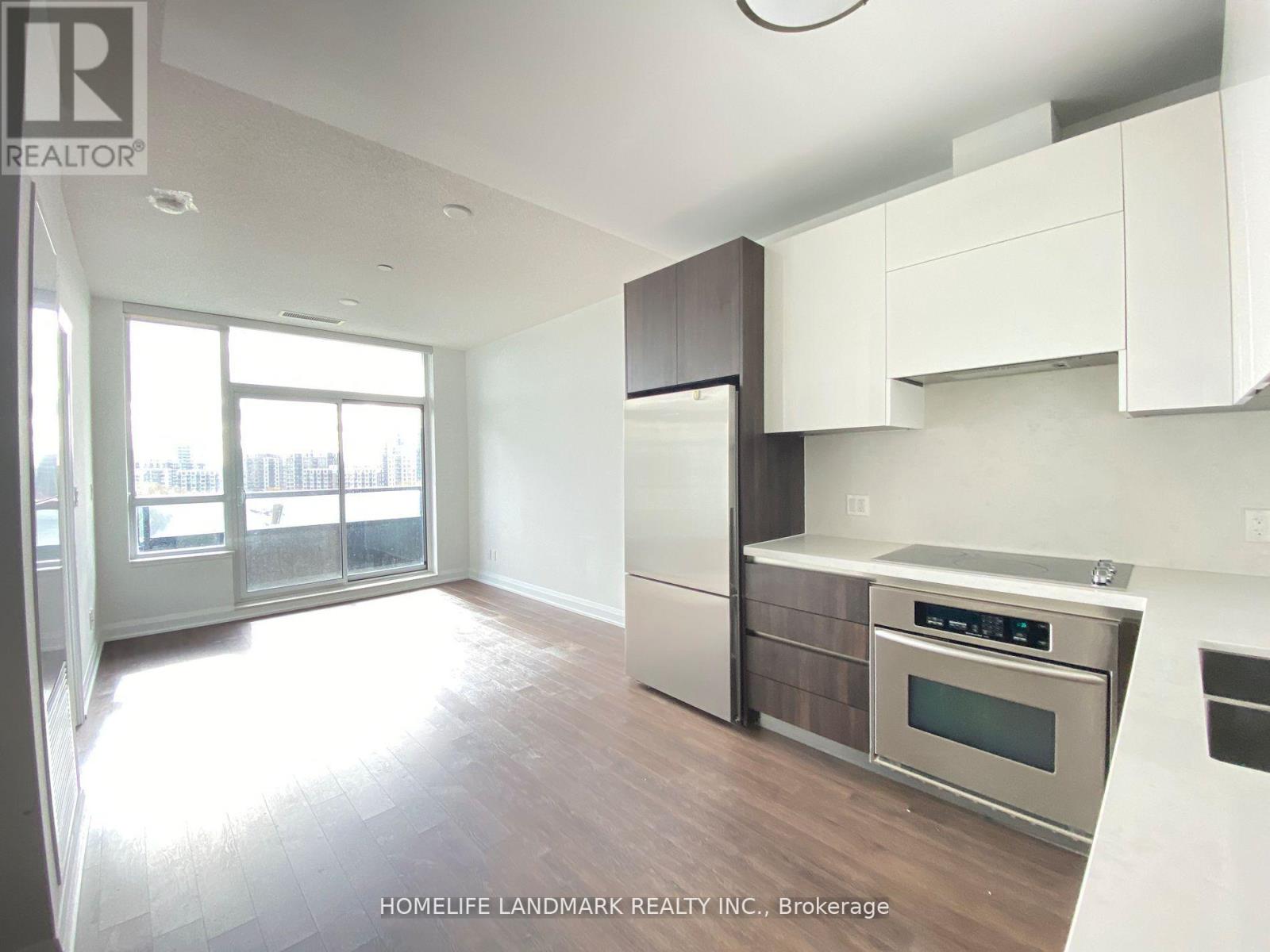 A modern kitchen with white cabinets and stainless steel appliances.