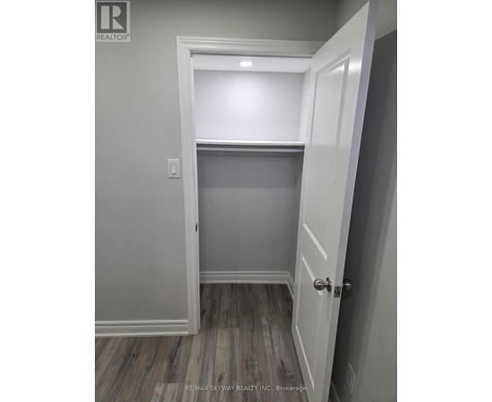 A white door is open to a room with grey walls.