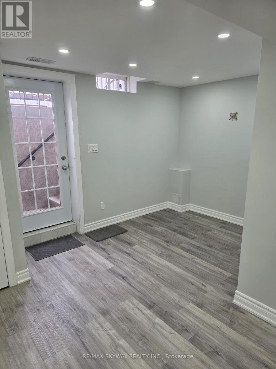 A room with a wooden floor and a white door.