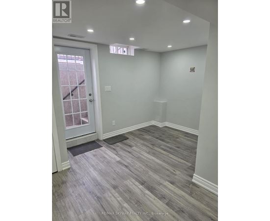A room with a wooden floor and a white door.