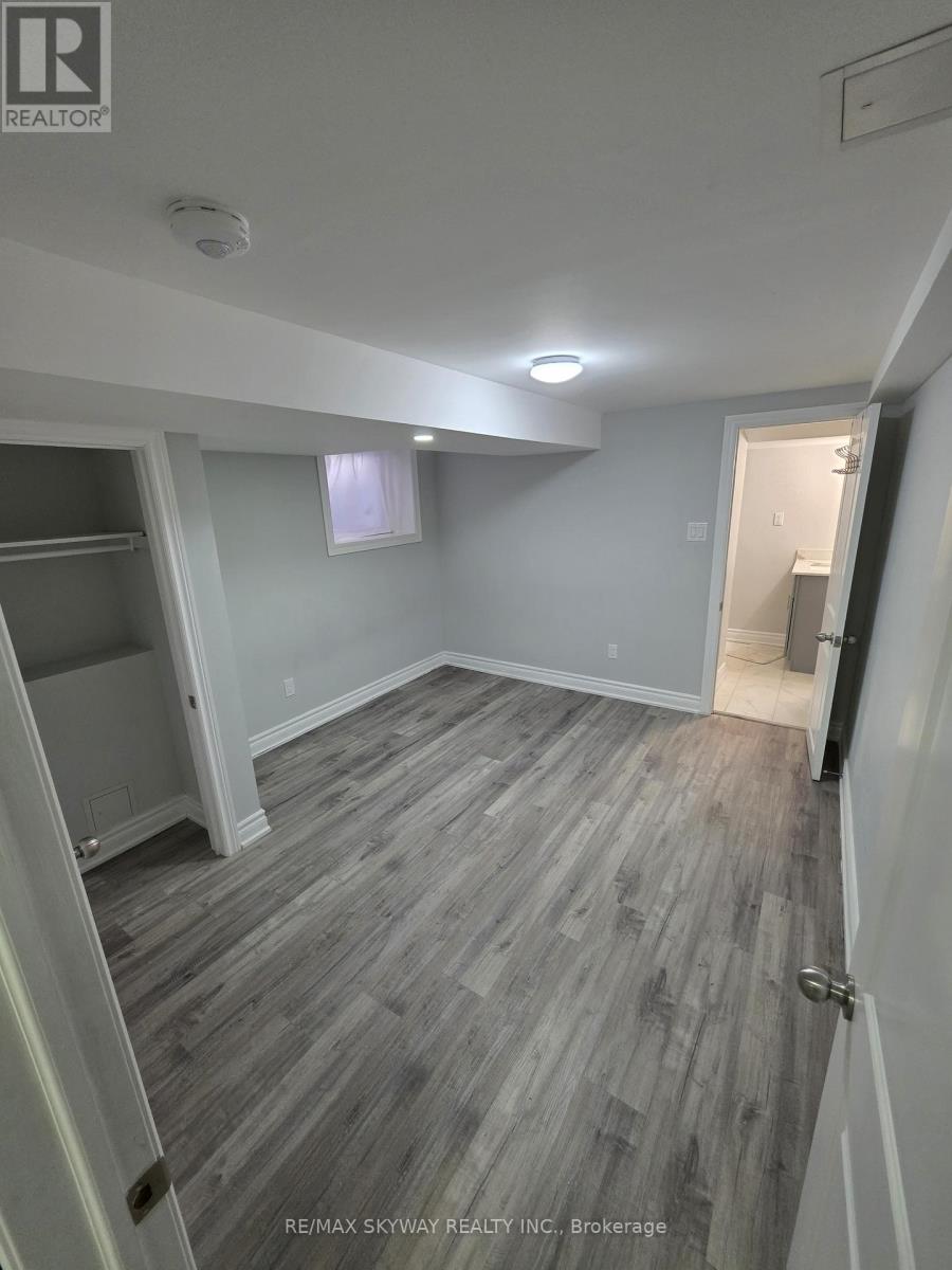 A room with grey wooden flooring and white walls.