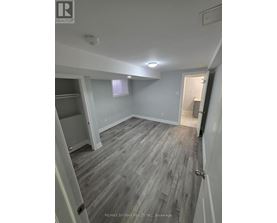 A room with grey wooden flooring and white walls.