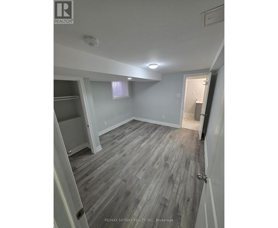 A room with grey wooden flooring and white walls.