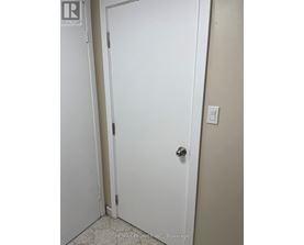 A white door with a silver handle in a room.