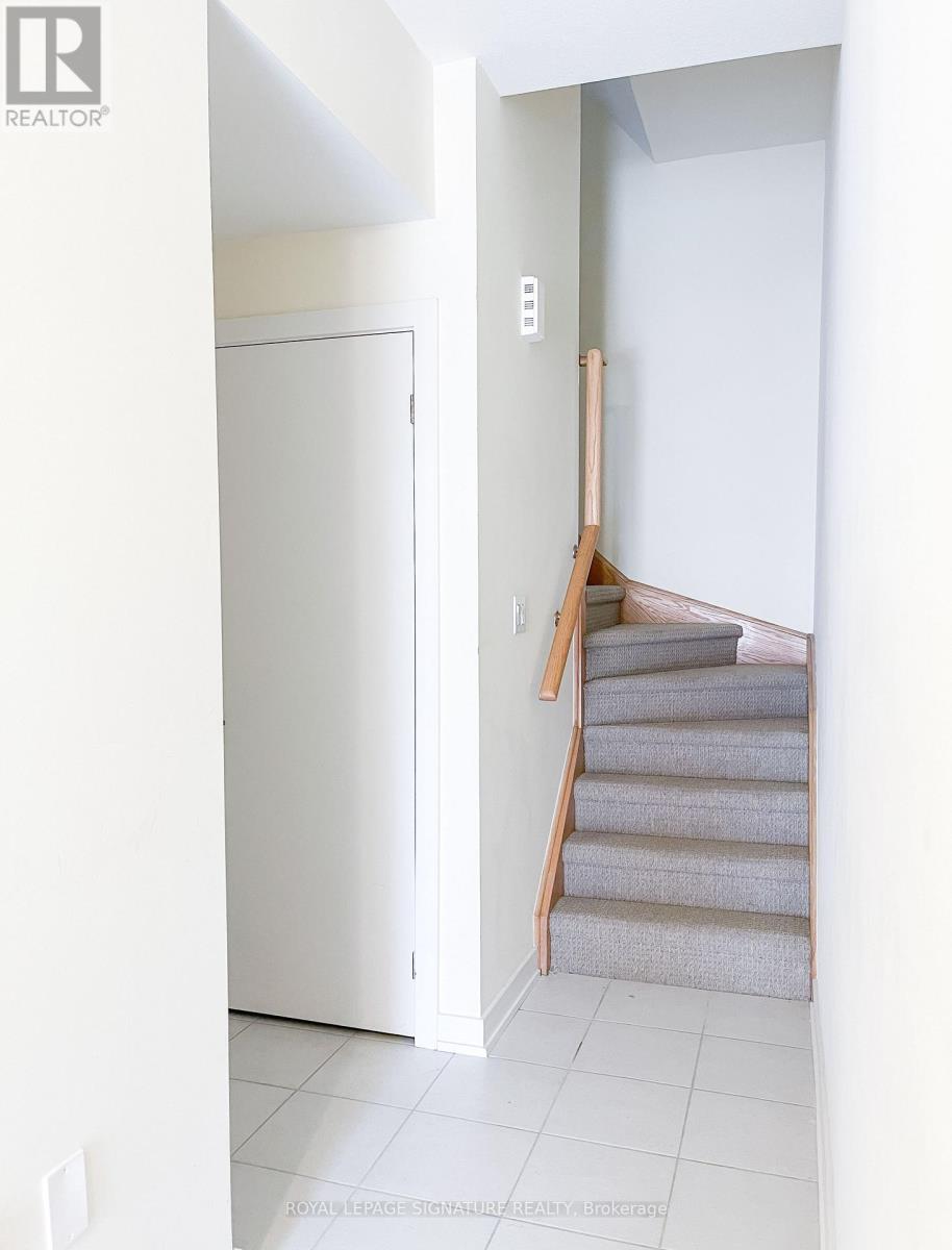 A staircase with a white door and a white wall.