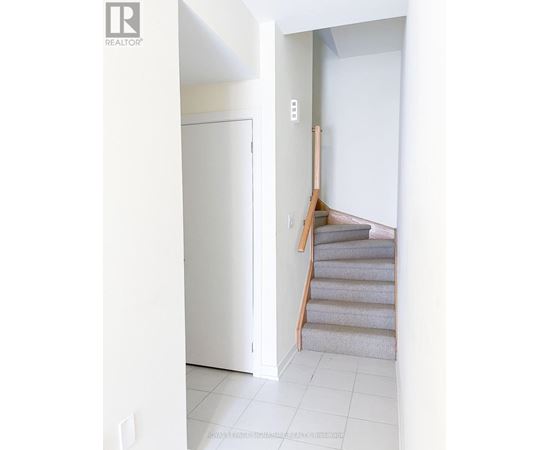 A staircase with a white door and a white wall.