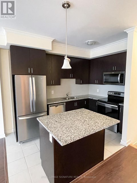 A kitchen with a granite counter top and stainless steel appliances.