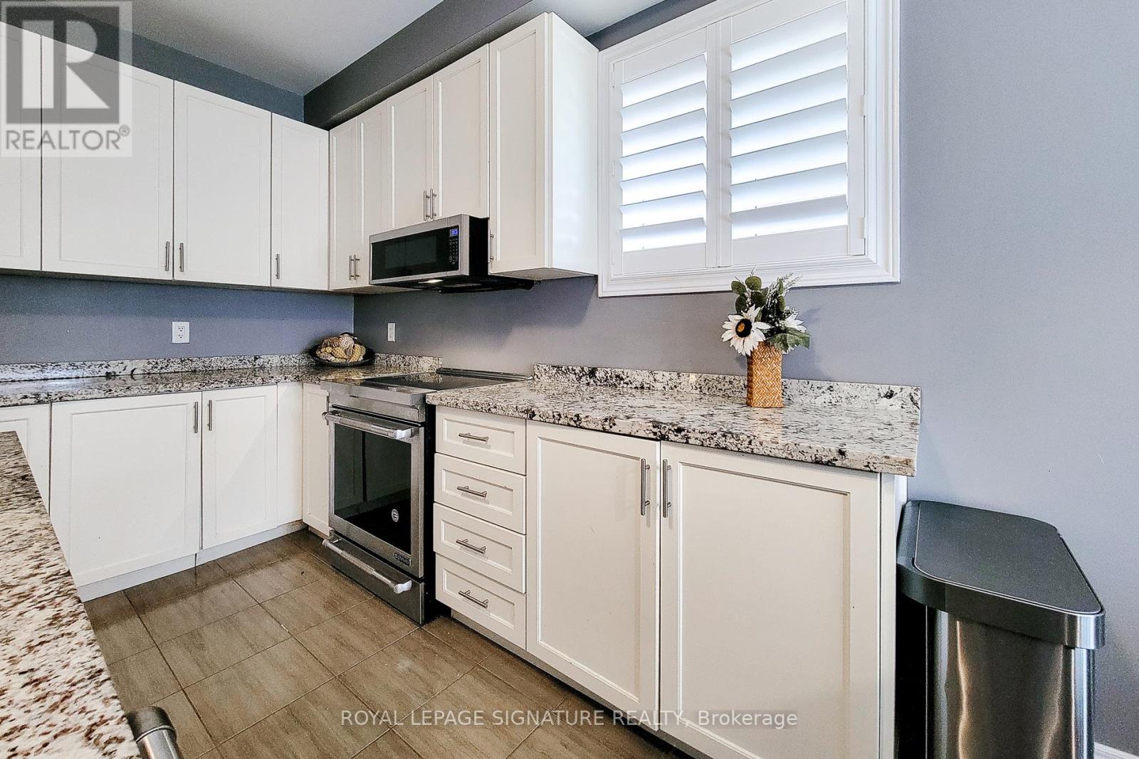 A kitchen with white cabinets and a granite countertop.