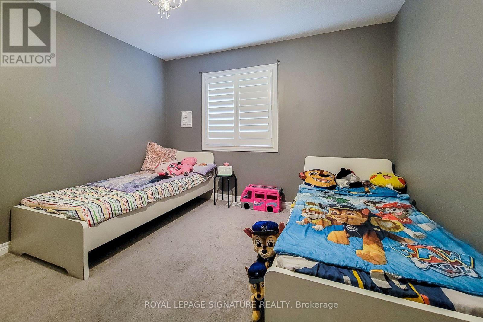 A bedroom with two beds and a pink toy car.