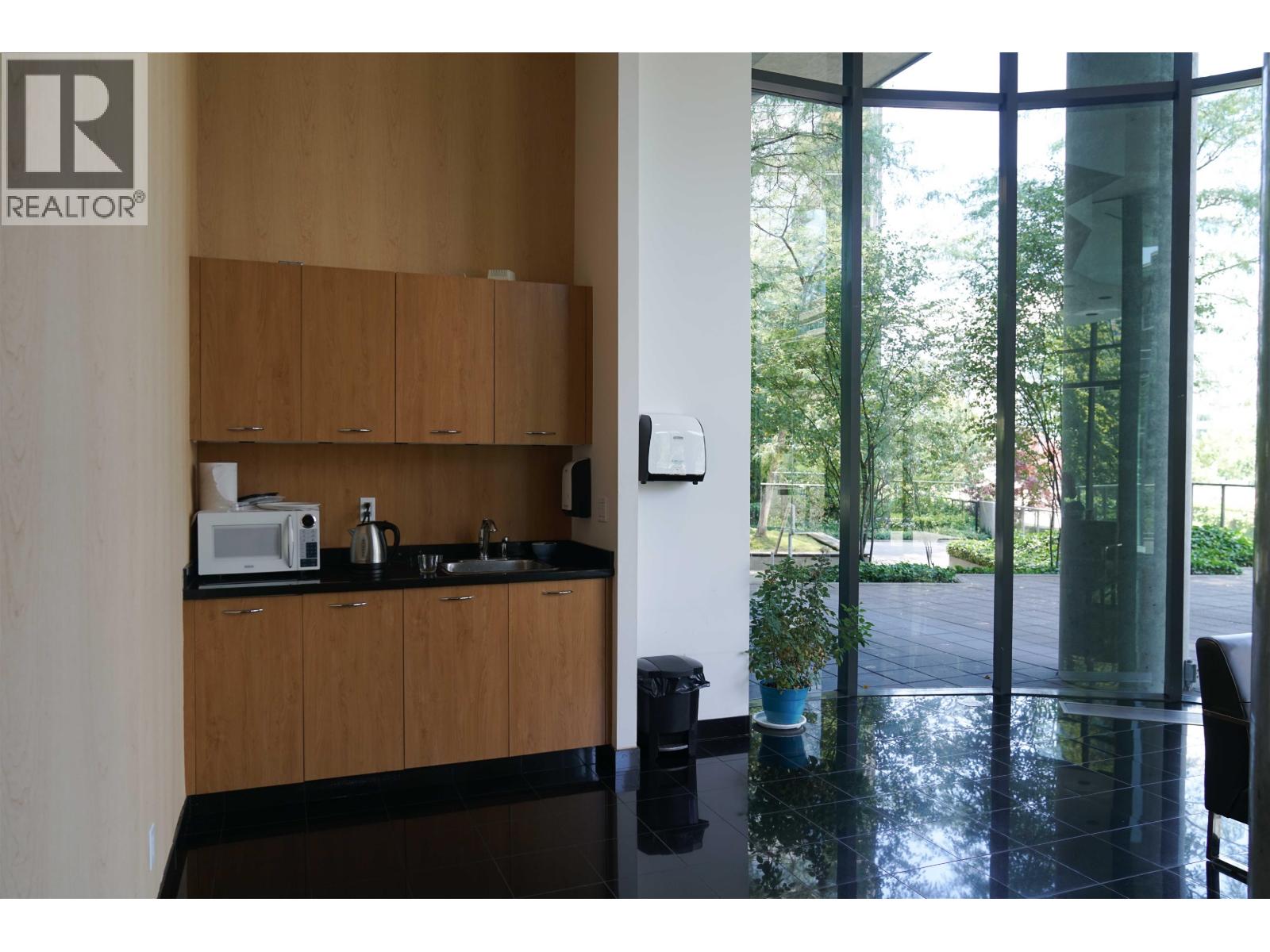 A kitchen with wooden cabinets and a black counter top.