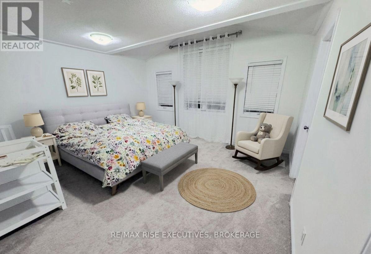 A bedroom with a bed, chair, and rug.