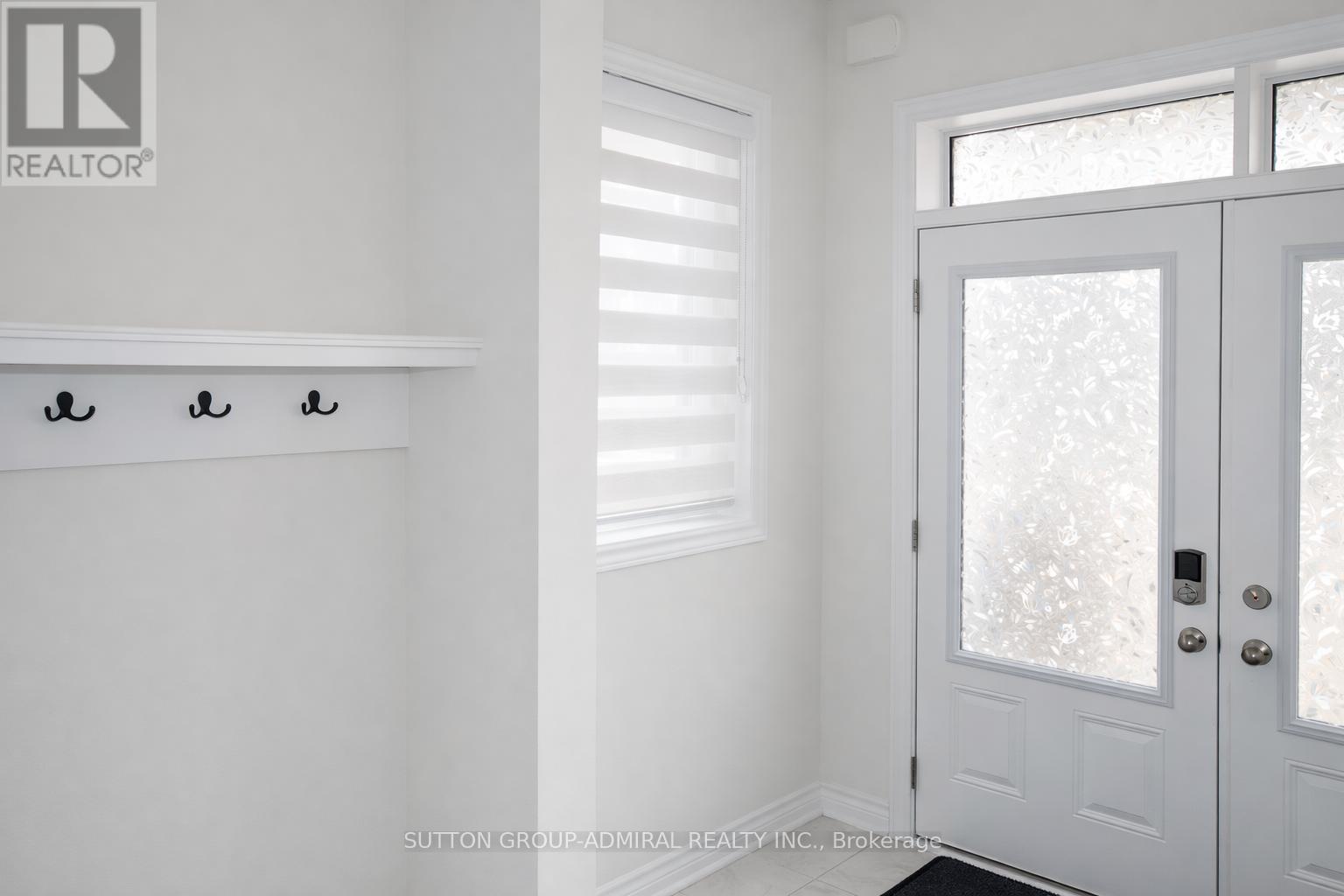 A white door with a glass window and a handle is in a room.