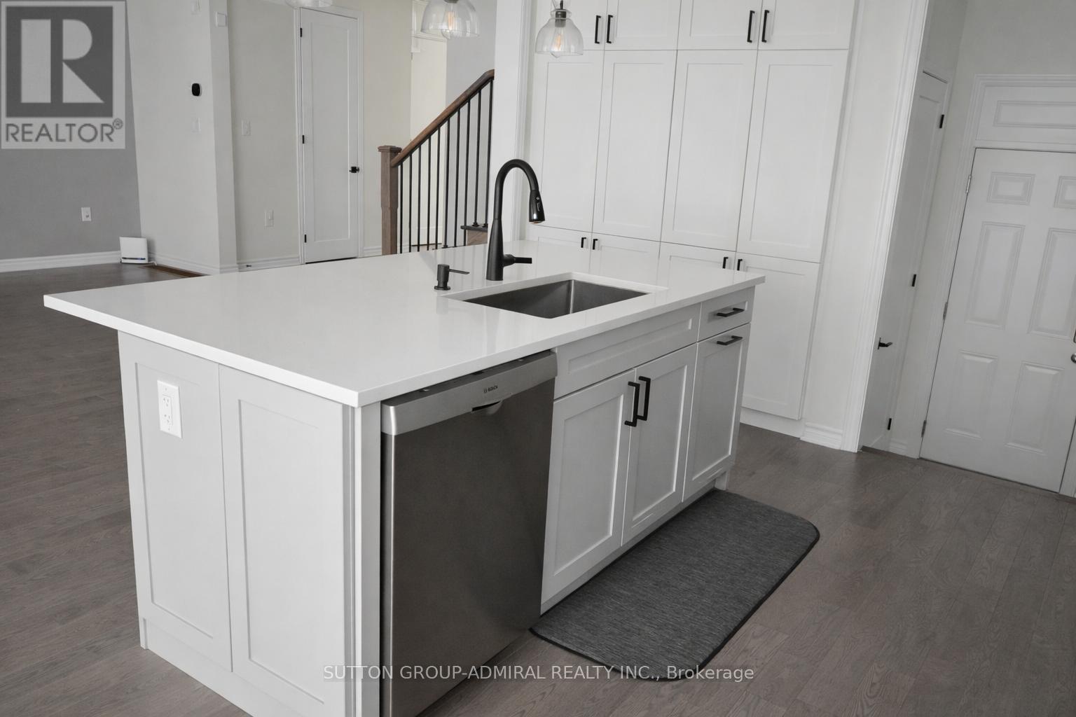 A kitchen with white cabinets and a sink.