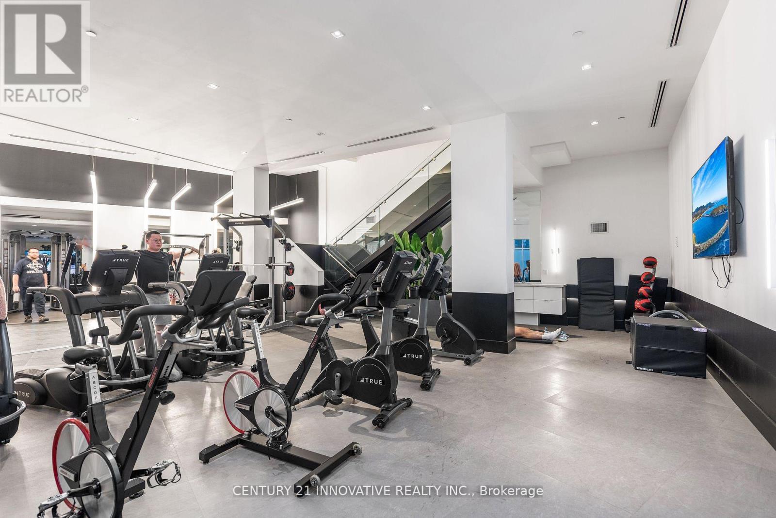 A gym with a variety of exercise equipment including treadmills, stationary bikes, and weight machines.