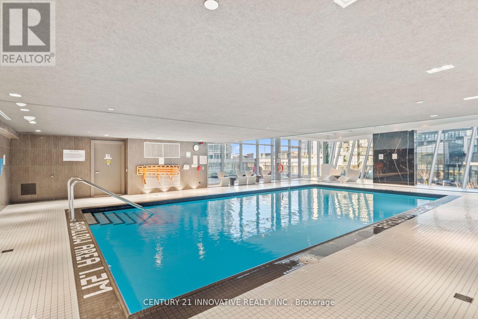 A swimming pool inside a building with the logo of REALTOR on the top left.