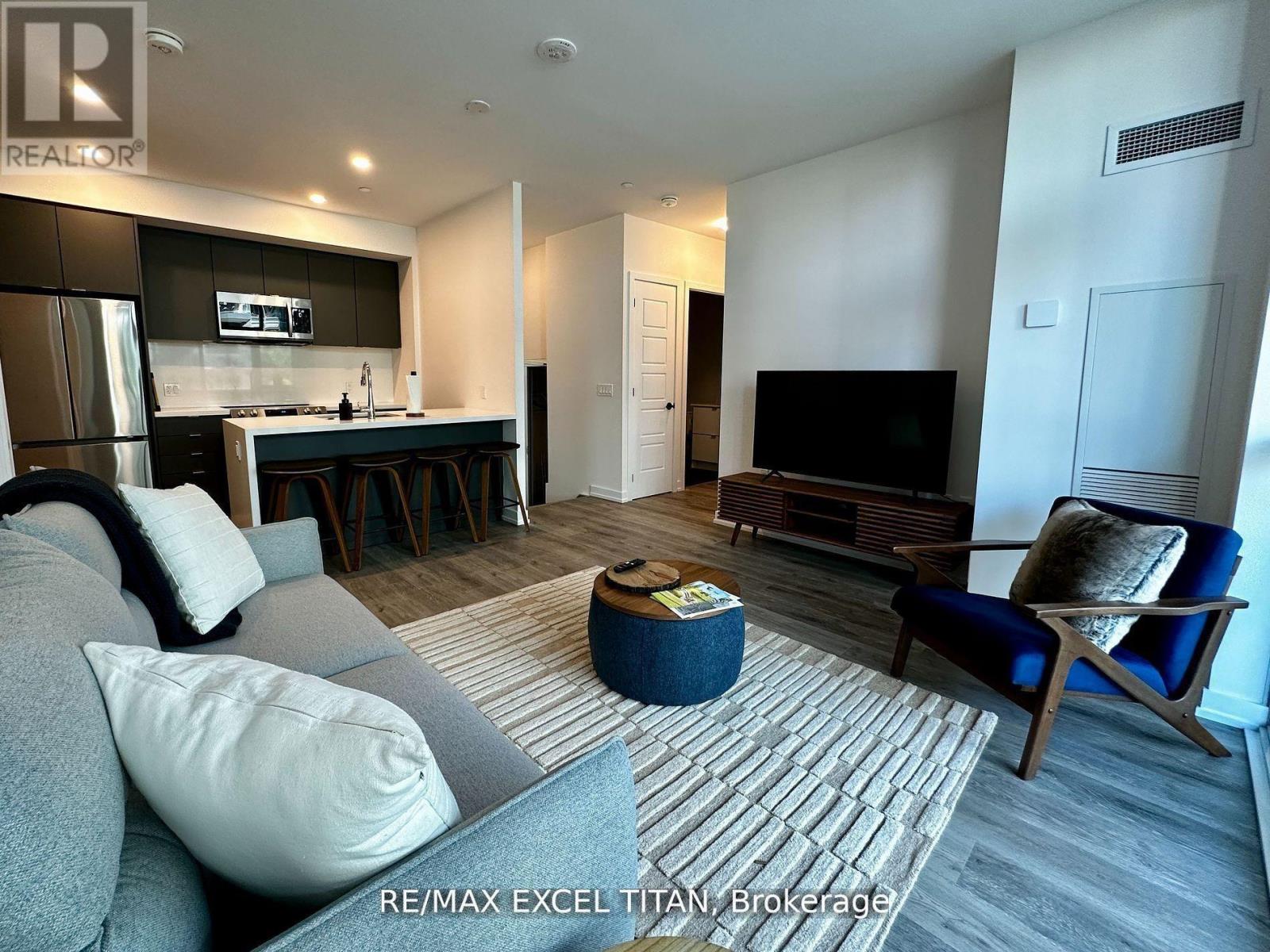 A modern living room with a grey couch and a blue armchair.