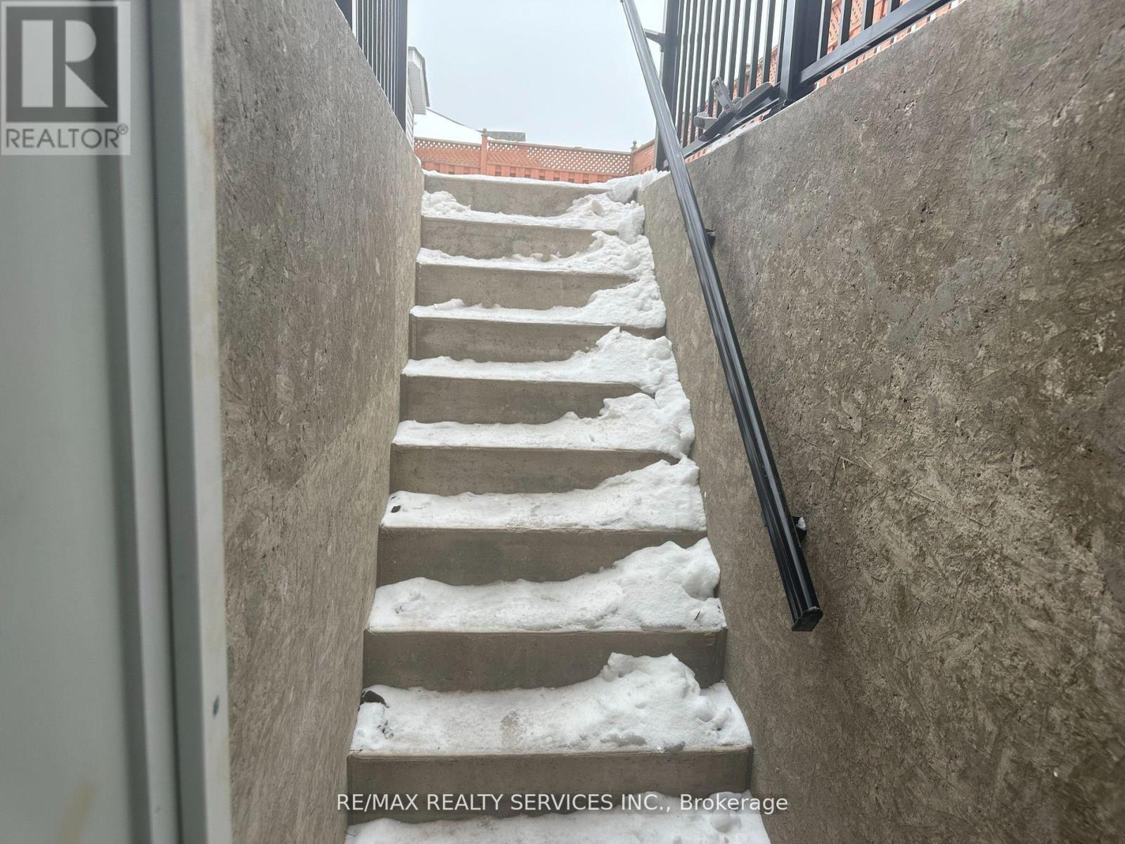 A staircase with a metal railing is covered in snow.