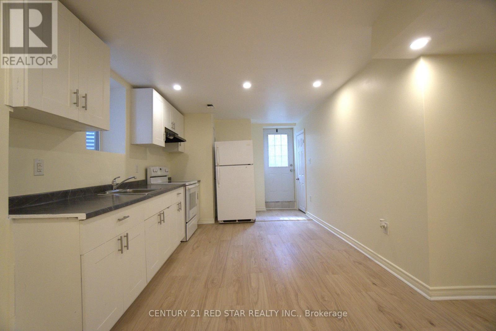 A kitchen with white cabinets and a black counter top.