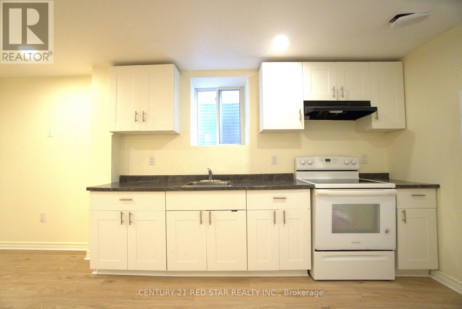A kitchen with white cabinets and a black countertop.