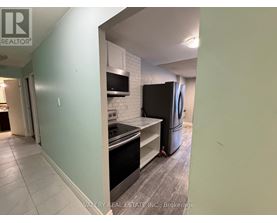 A kitchen with a stove top oven and a refrigerator.