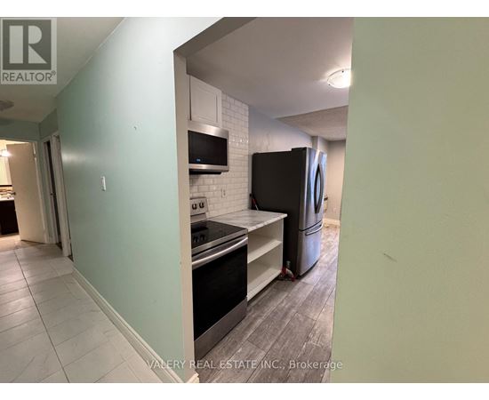 A kitchen with a stove top oven and a refrigerator.