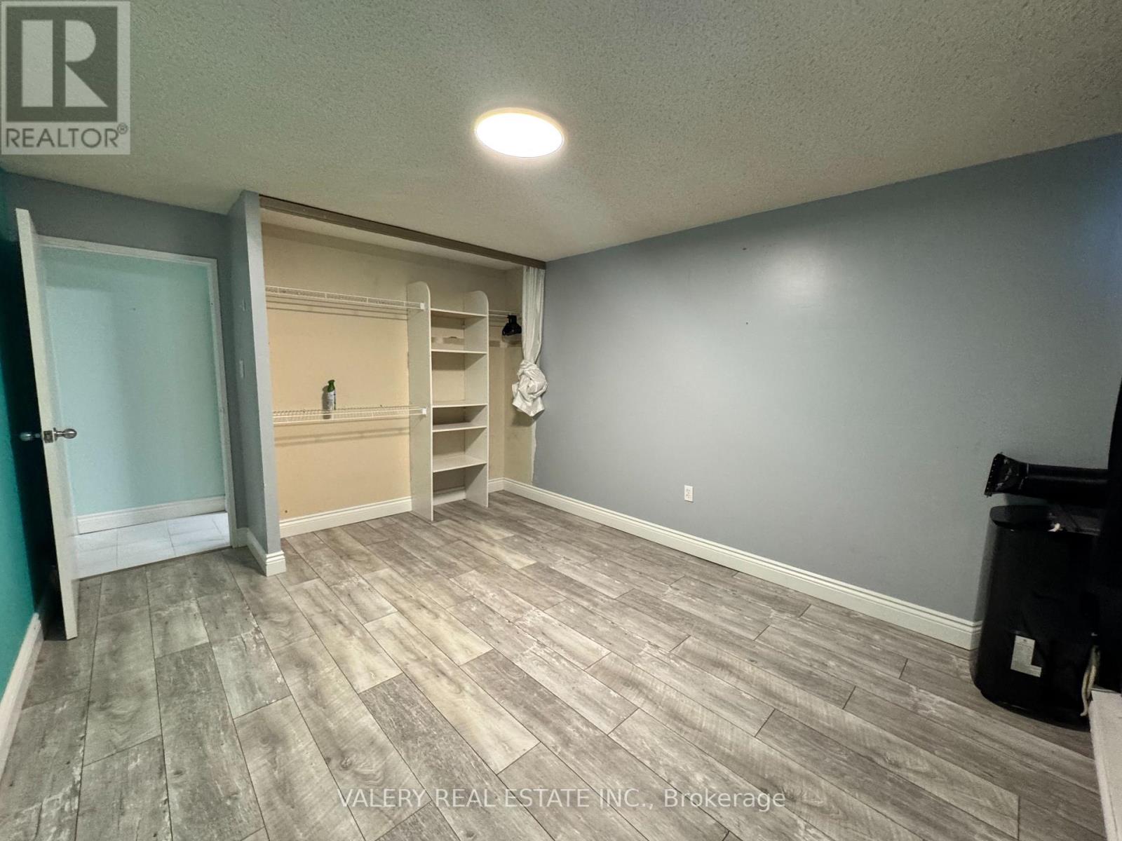 A room with a door and a wall with a shelf.