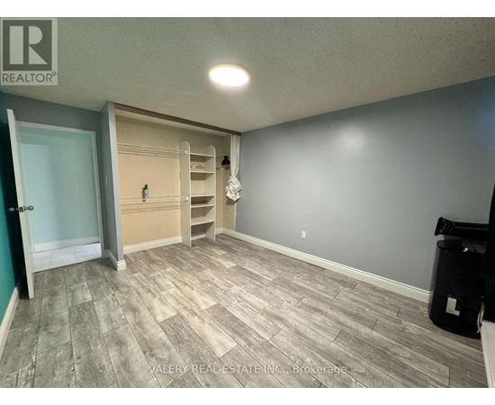 A room with a door and a wall with a shelf.