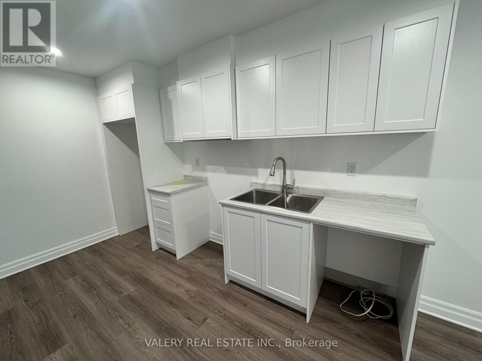 A kitchen with white cabinets and a sink.