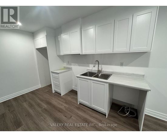 A kitchen with white cabinets and a sink.