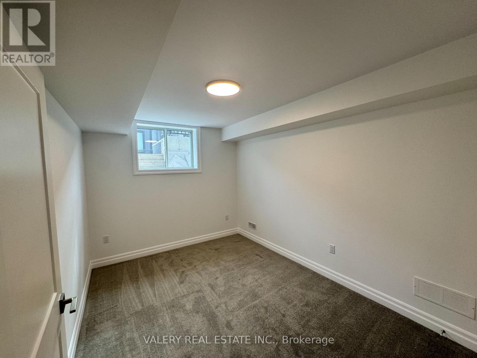 A room with a window and a door leading to another room.