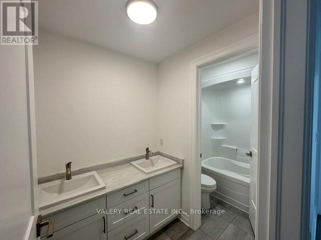 A bathroom with a sink, toilet, and bathtub.