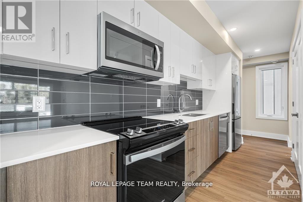 A modern kitchen with a stove top oven and microwave above it.